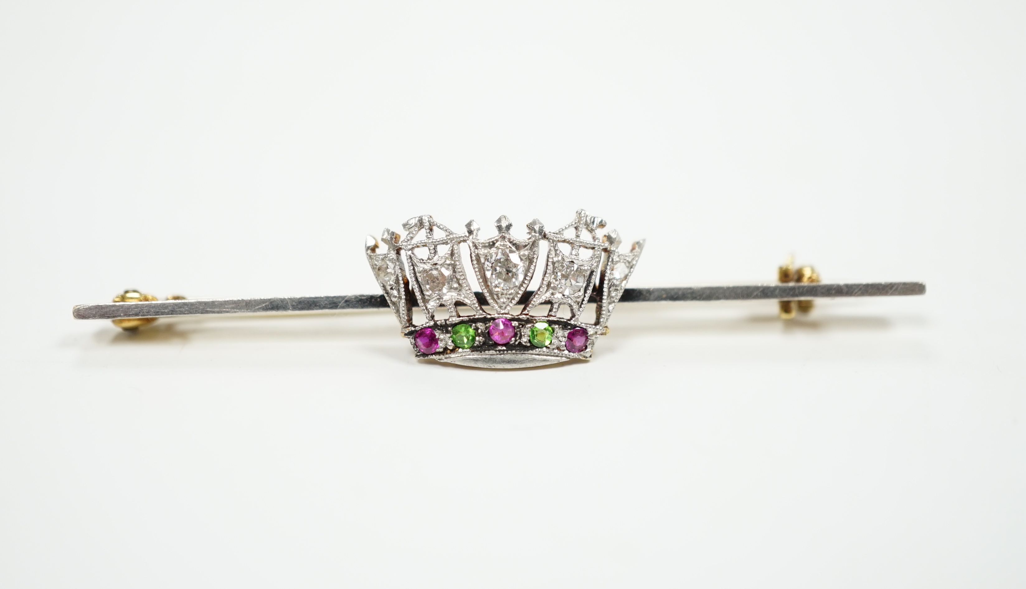 An early 20th century, 15ct and plat. ruby, green garnet and diamond set coronet bar brooch, 50mm, gross weight 3.4 grams.